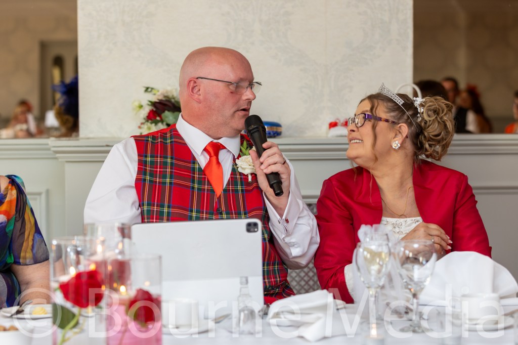 DAniel and Elizabeth look at each other as Daniel is speaking into a microphone.