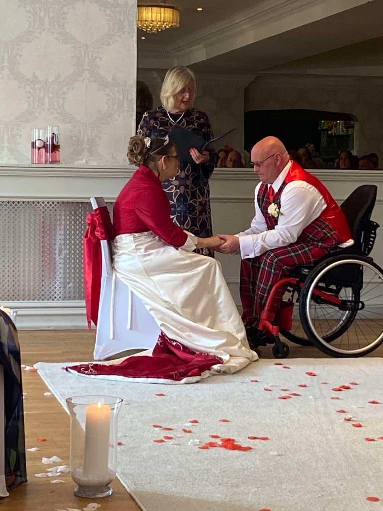 Daniel and Elizabeth hold hands while the humanist celebrant reads their personal vows out.